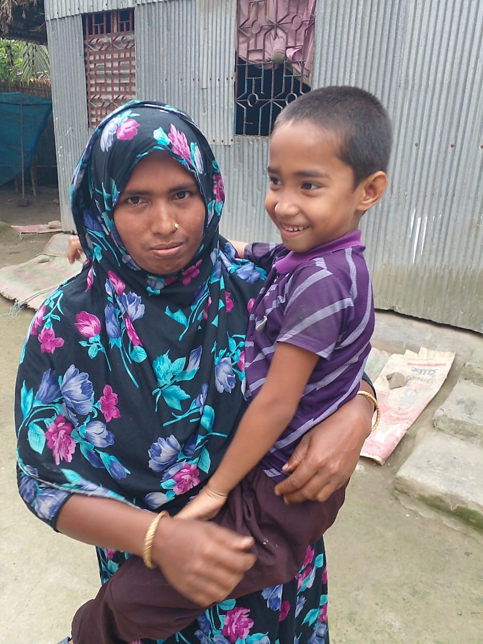 Sojina holds her smiling child on her hips as they are reunited after two years. 