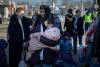 Woman clutches baby in pink blanket